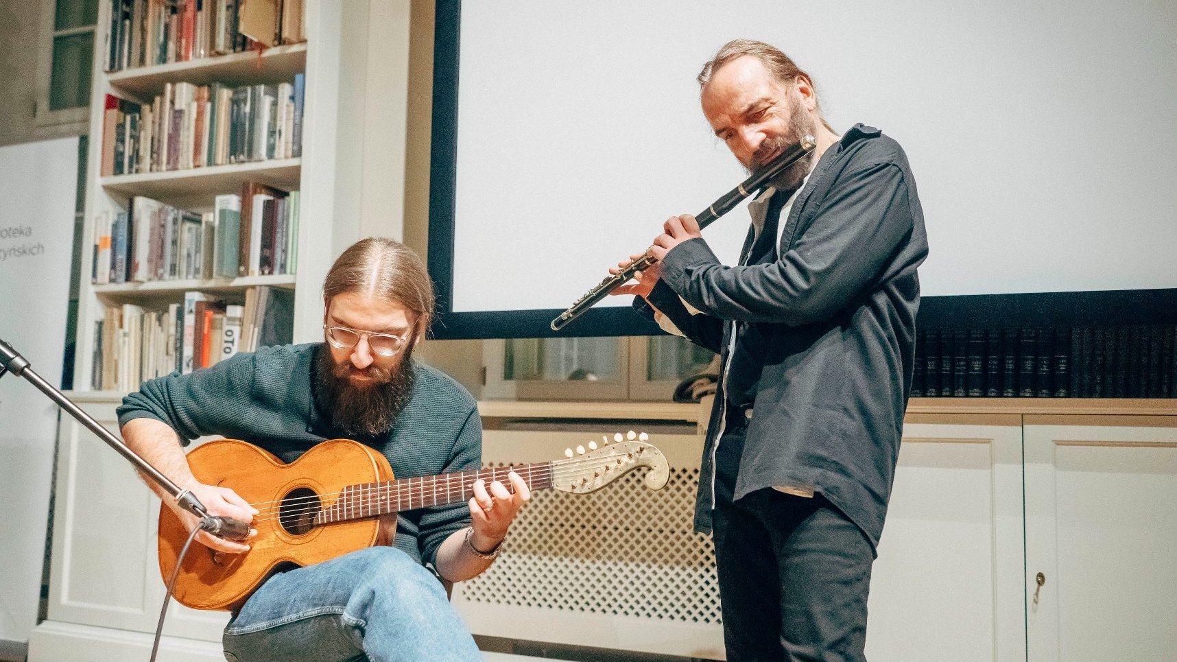 artyści grają na instrumentach, na flecie oraz na gitarze