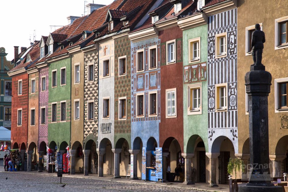 Kolorowe domki budnicze z podcieniami na Starym Rynku w Poznaniu, z prawej strony pomnik - pręgierz. - grafika artykułu