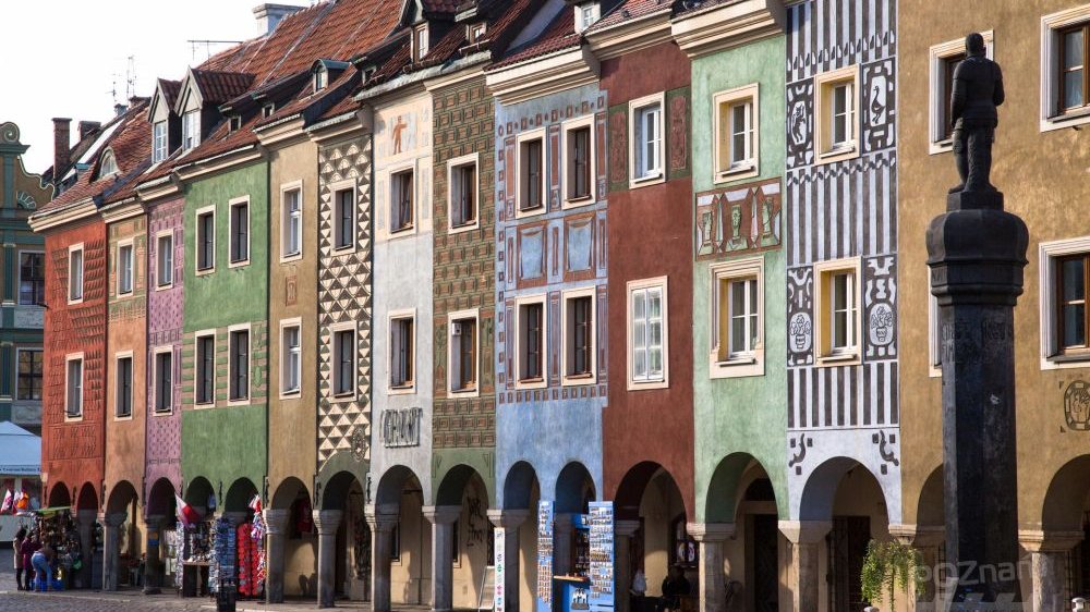 Kolorowe domki budnicze z podcieniami na Starym Rynku w Poznaniu, z prawej strony pomnik - pręgierz.