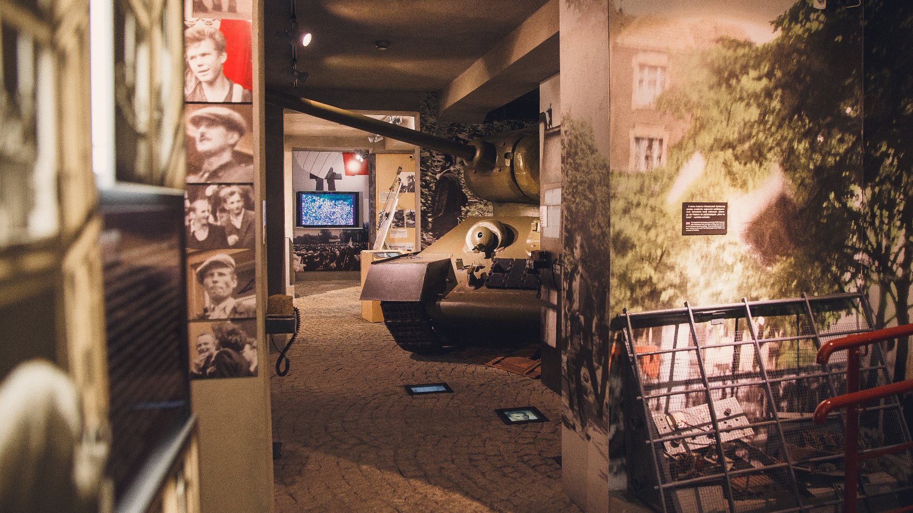 Część ekspozycji muzealnej Poznańskiego Czerwca 1956. W centrum widać część czołgu. Dookoła na ścianach wiszą zdjęcia uczestników strajku. W tle ekran telewizora, na którym wyświetlone jest przemówienie Stanisława Matyi z uroczystości odsłonięcia pomnika "Jedność".