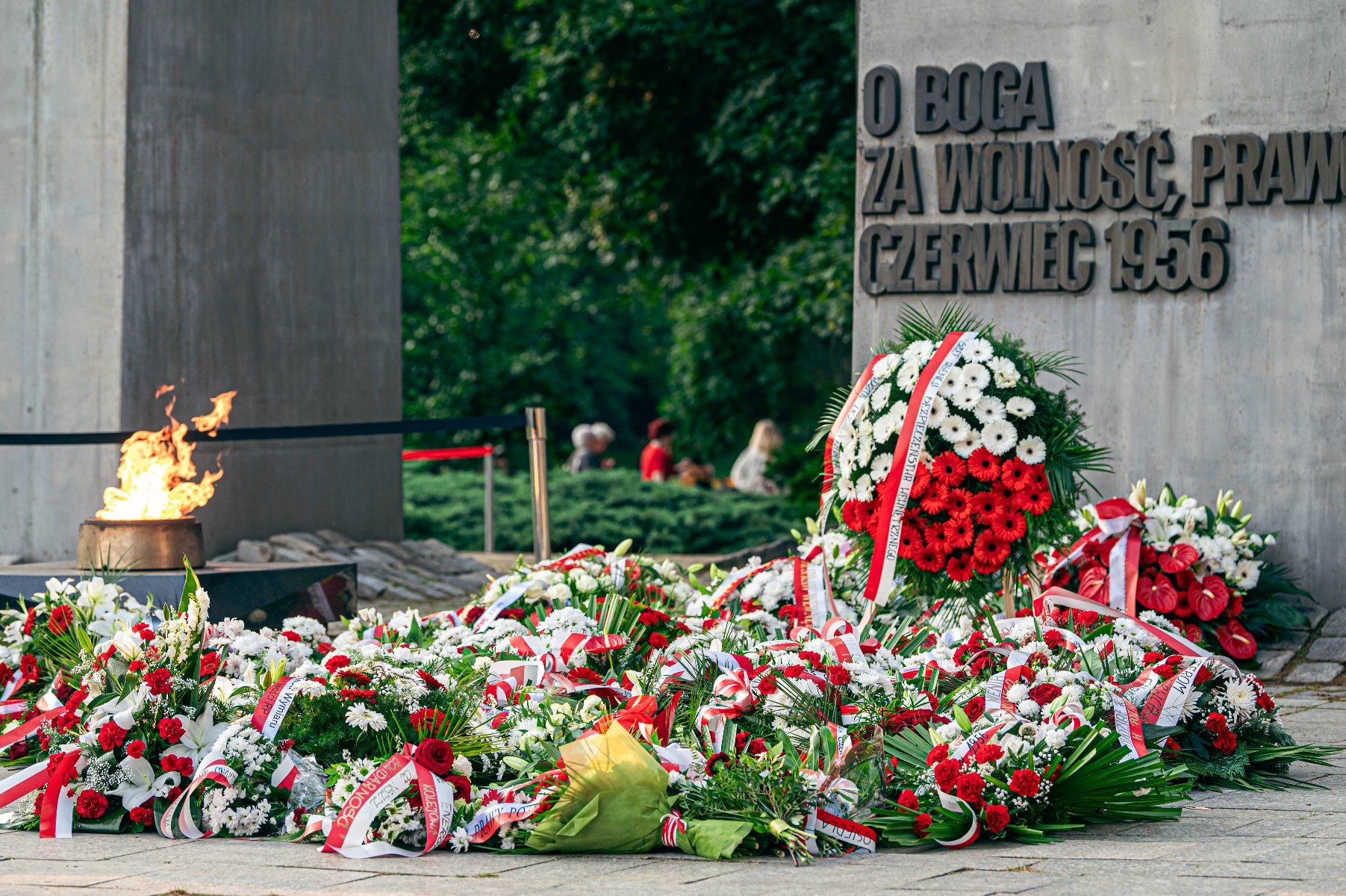 Na zdjęciu pomnik, pod nim kwiaty i płonący znicz - grafika artykułu