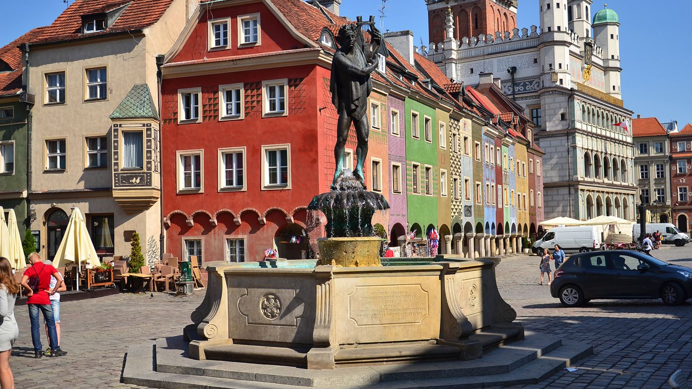 Zdjęcie przedstawia studnię w kształcie ośmioboku wykonana jest z piaskowca, fontannę wieńczy cokół z figurą Apollina wykonaną z brązu. W tle fontanny widoczny jest ratusz.