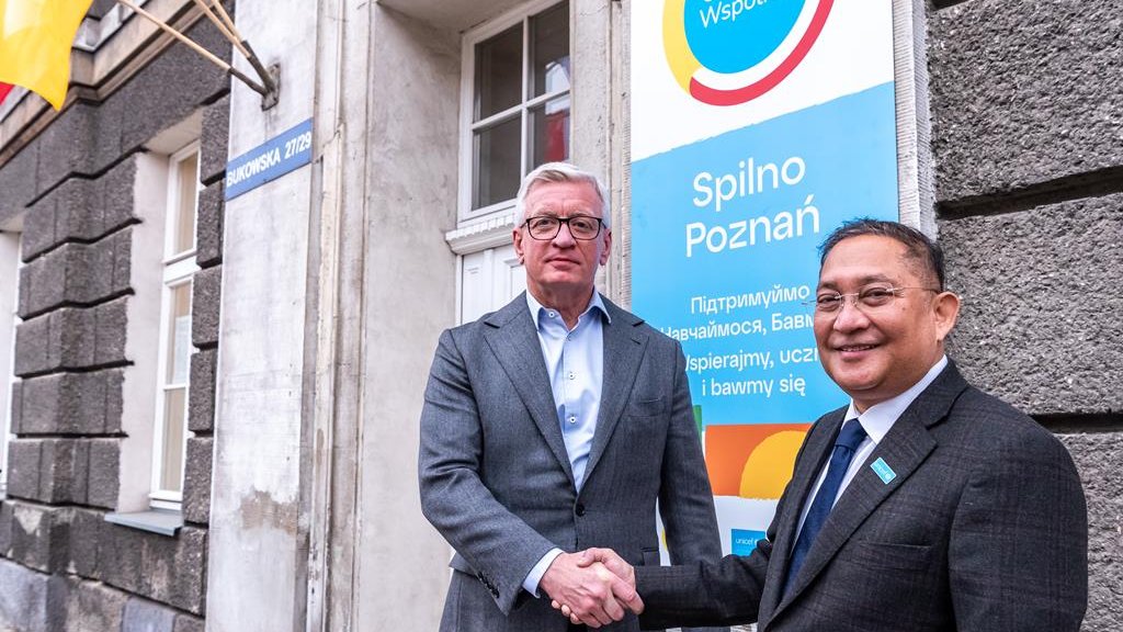 Na zdjęciu dwóch mężczyzn - w tym prezydent Poznania - podających sobie dłonie przed siedzibą "Spilno"
