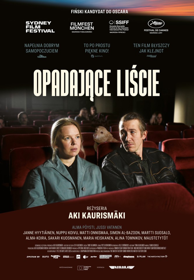 Plakat przedstawia dwie osoby, kobietę i mężczyznę, siedzących w kinie. Fotele mają kolor czerwony, a pomiędzy postaciami siedzi mały piesek. Mężczyzna spogląda na zapatrzoną w kinowy ekran kobietę.