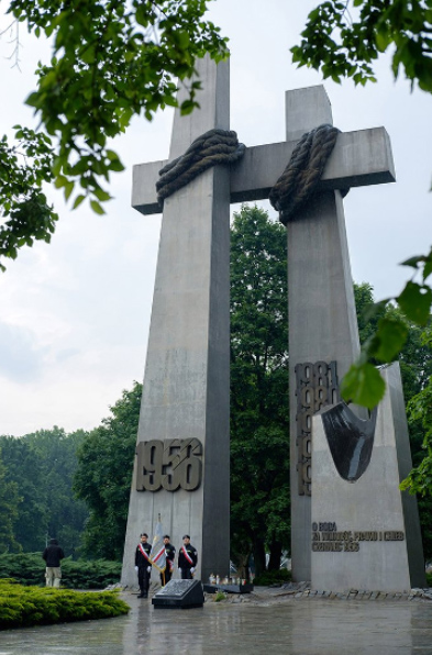Pomnik dwa krzyżę - napis 1956, wiązanki kwiatów
