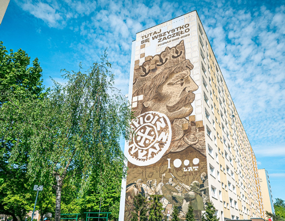 Impreza odbędzie się w sobotę, 23 sierpnia w parku im. Tadeusza Kasserna na os. Bolesława Chrobrego. Wcześniej na tym osiedlu powstał m.in. mural nawiązujący do koronacji pierwszego króla Polski. Zdjęcie przedstawia duży mural z podobizną Bolesława Chrobrego umieszczony na ścianie bloku.