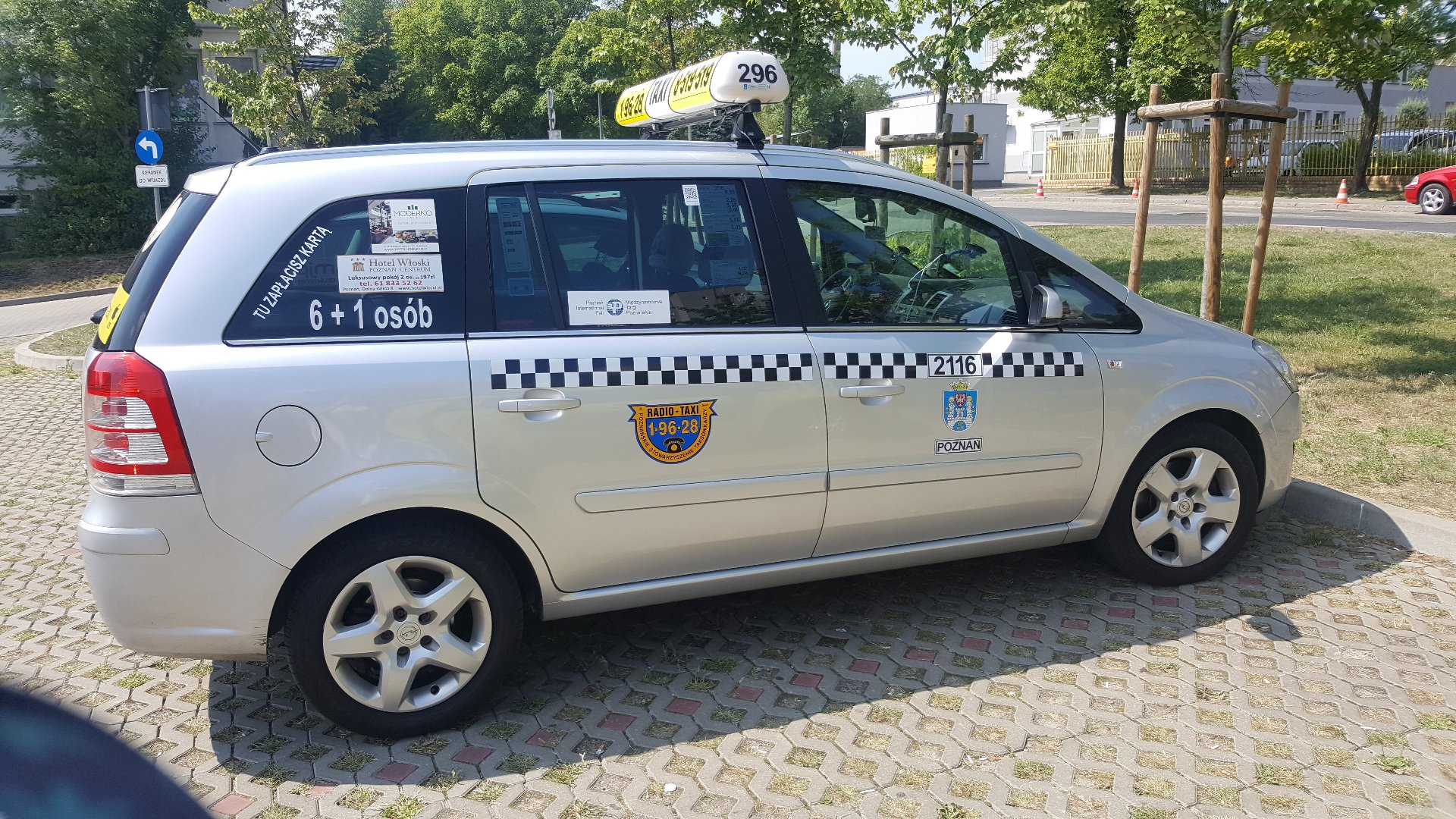 Zdjęcie taxi z QR kodem na drzwiach.