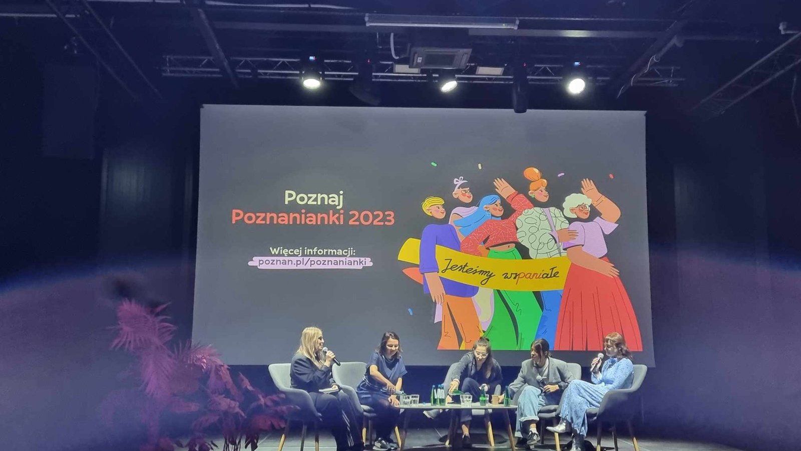 Na zdjęciu uczestniczki debaty na scenie, za nimi grafika: Poznanianki 2023