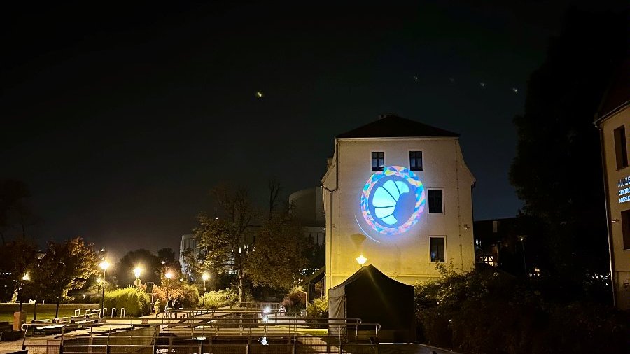 Zdjęcie przedstawia hologram rogala świętomarcińskiego wyświetlany na Europejskim Centrum Pieniądza w Bydgoszczy,