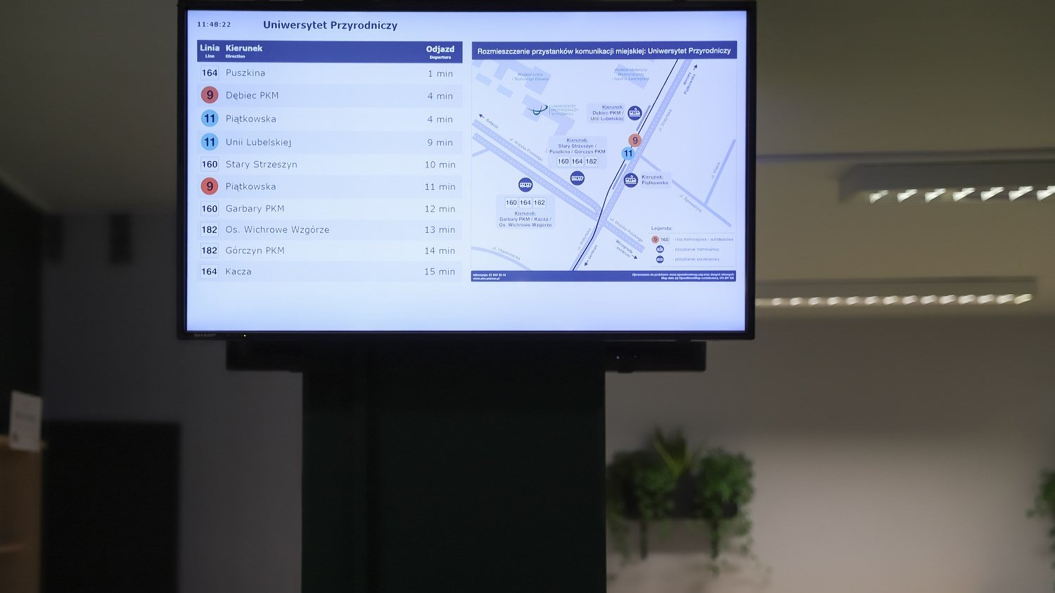 Tablica multimedialna, na której wyświetlane są informacje o odjazdach tramwajów i autobusów z najbliższych przystanków