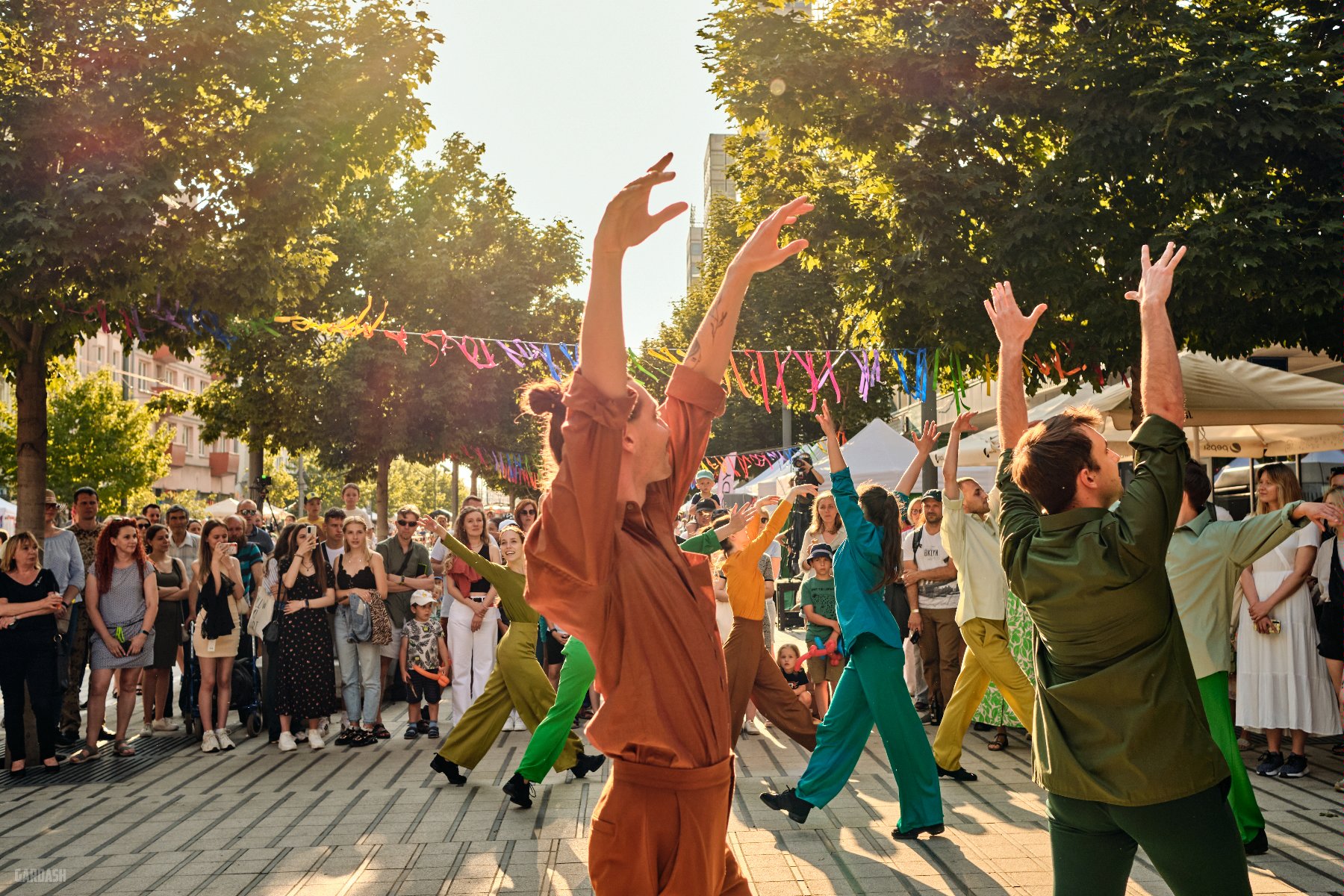 Na zdjęciu młodzi ludzie tańczący na ulicy Święty Marcin - grafika artykułu