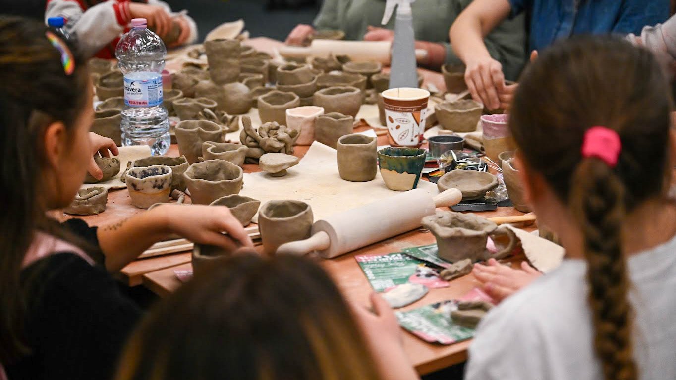 Na zdjeciu dzieci lepiące ceramikę